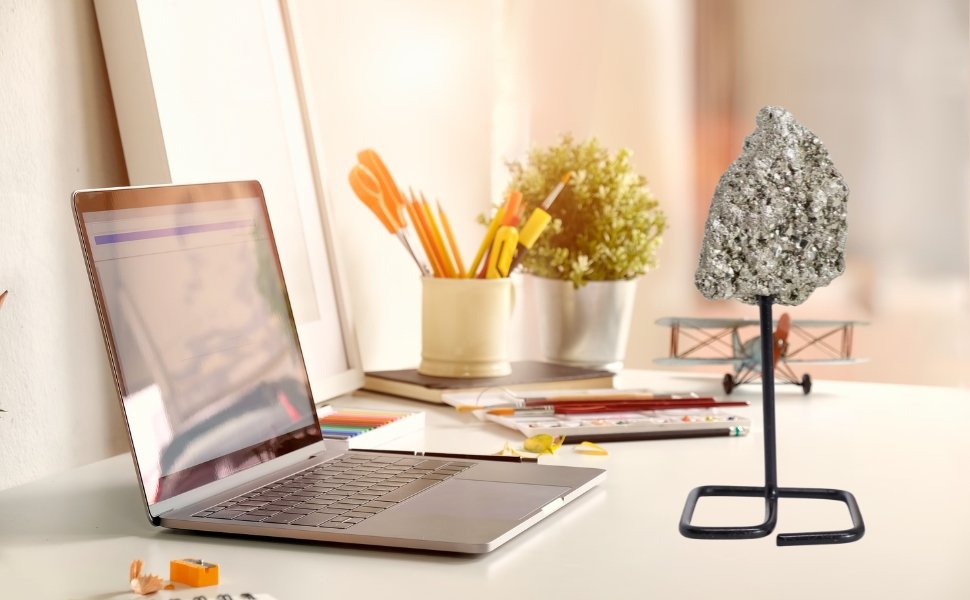 Pyrite on a metal stand placed on a clean modern office workspace next to a laptop