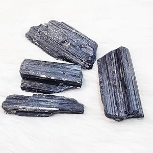 Multiple raw black tourmaline crystal chunks aligned horizontally