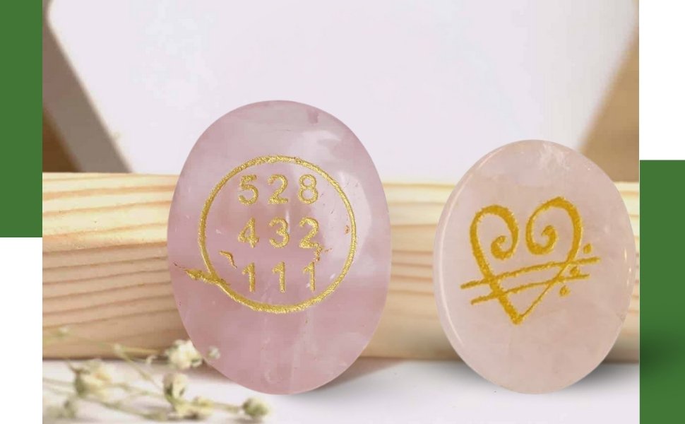 Close up view of engraved gold detailing on pink rose quartz pocket stones